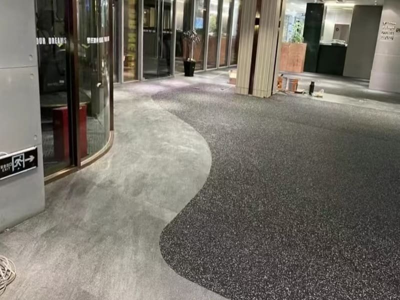 A stack of rubber gym floor tiles showing the different thickness layers